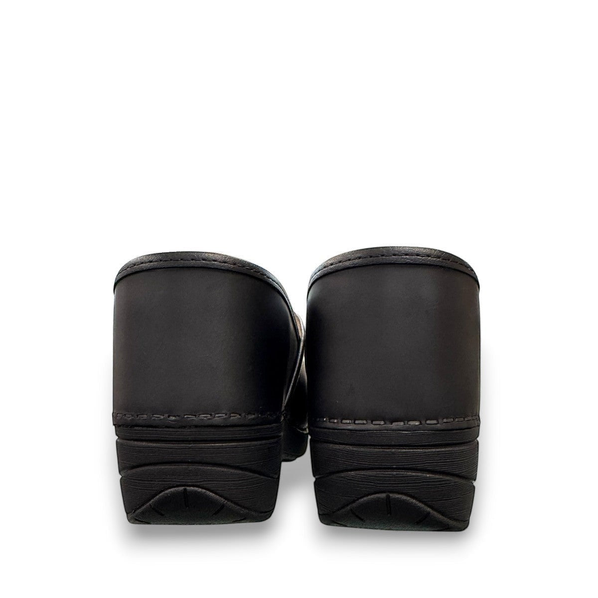 Dansko XP 2.0 black waterproof leather performance clog showing the slip-resistant rubber outsole. Photo of back view.