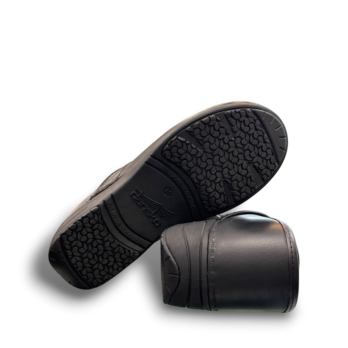 Dansko XP 2.0 black waterproof leather performance clog showing the slip-resistant rubber outsole. Photo of bottom view.