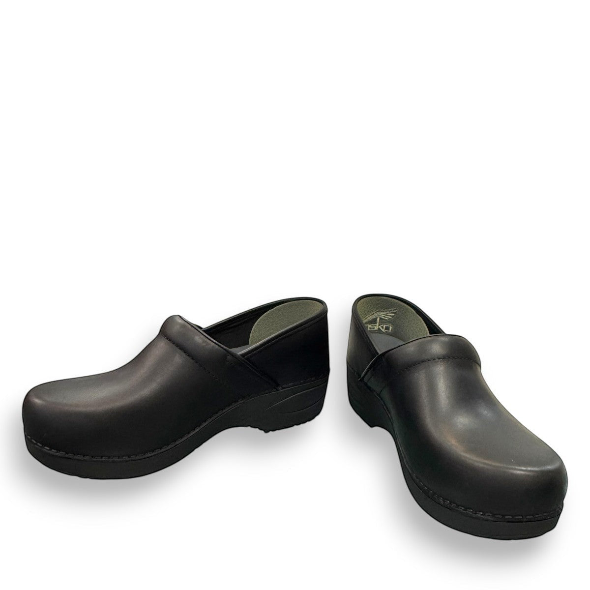 Dansko XP 2.0 black waterproof leather performance clog showing the slip-resistant rubber outsole. Photo of front view at an angle.