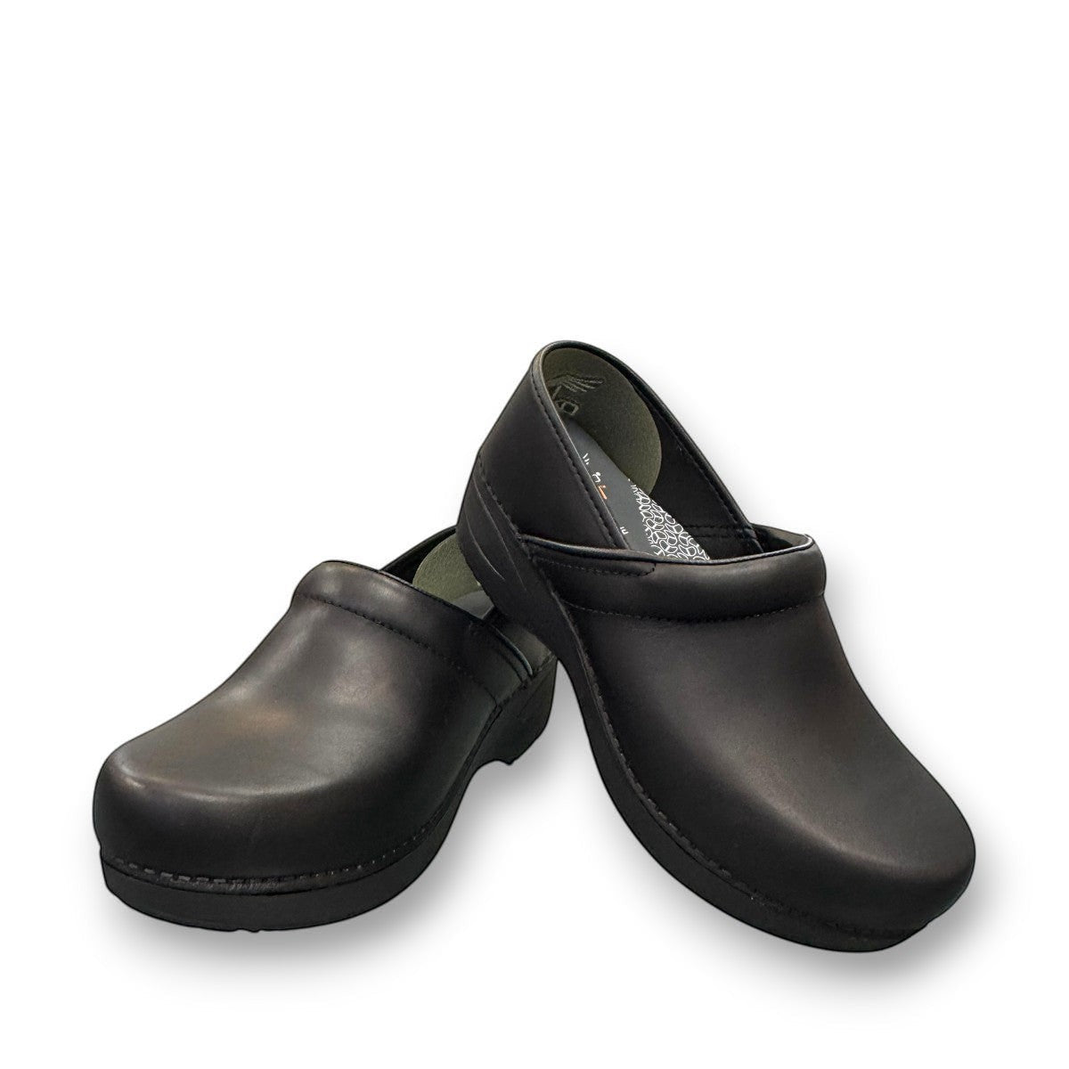Dansko XP 2.0 black waterproof leather performance clog showing the slip-resistant rubber outsole. Photo of front view.