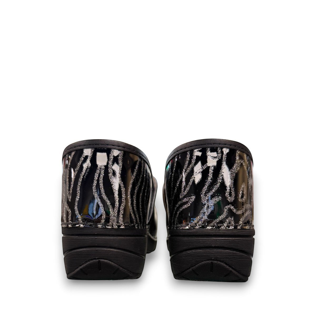 Dansko XP 2.0 patent clog showing the black slip-resistant rubber outsole and glitter wave pattern. Photo of back view.
