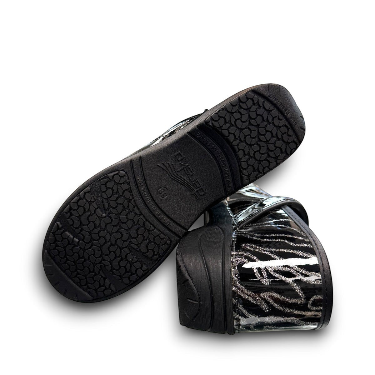 Dansko XP 2.0 patent clog showing the black slip-resistant rubber outsole and glitter wave pattern. Photo of bottom view.
