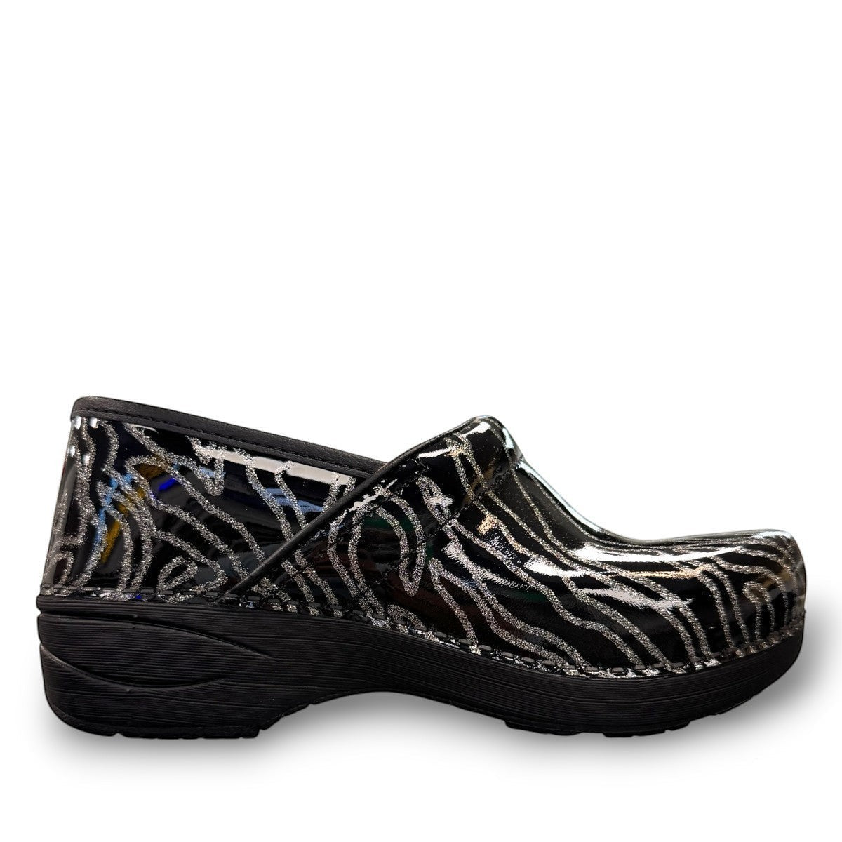 Dansko XP 2.0 patent clog showing the black slip-resistant rubber outsole and glitter wave pattern. Photo of right outside side view.