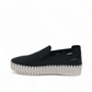 Django & Juliette black leather slip-on sneakers with perforated detail and thick white cleated sole. Photo of left side view.