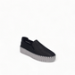 Django & Juliette black leather slip-on sneakers with perforated detail and thick white cleated sole. Photo of front side view.