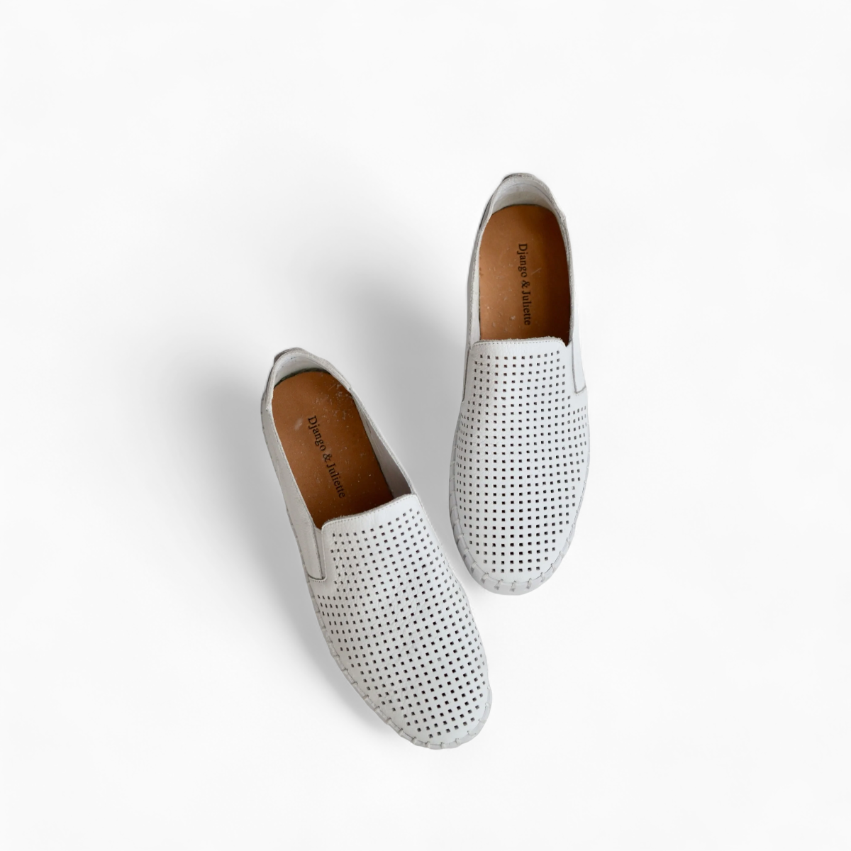 Django & Juliette white leather slip-on sneakers with perforated upper and thick cleated sole. Photo of upper view.