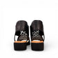 Django & Juliette Montaen black leather platform wedge sandals with laser-cut detailing and ankle strap. Photo of back view.