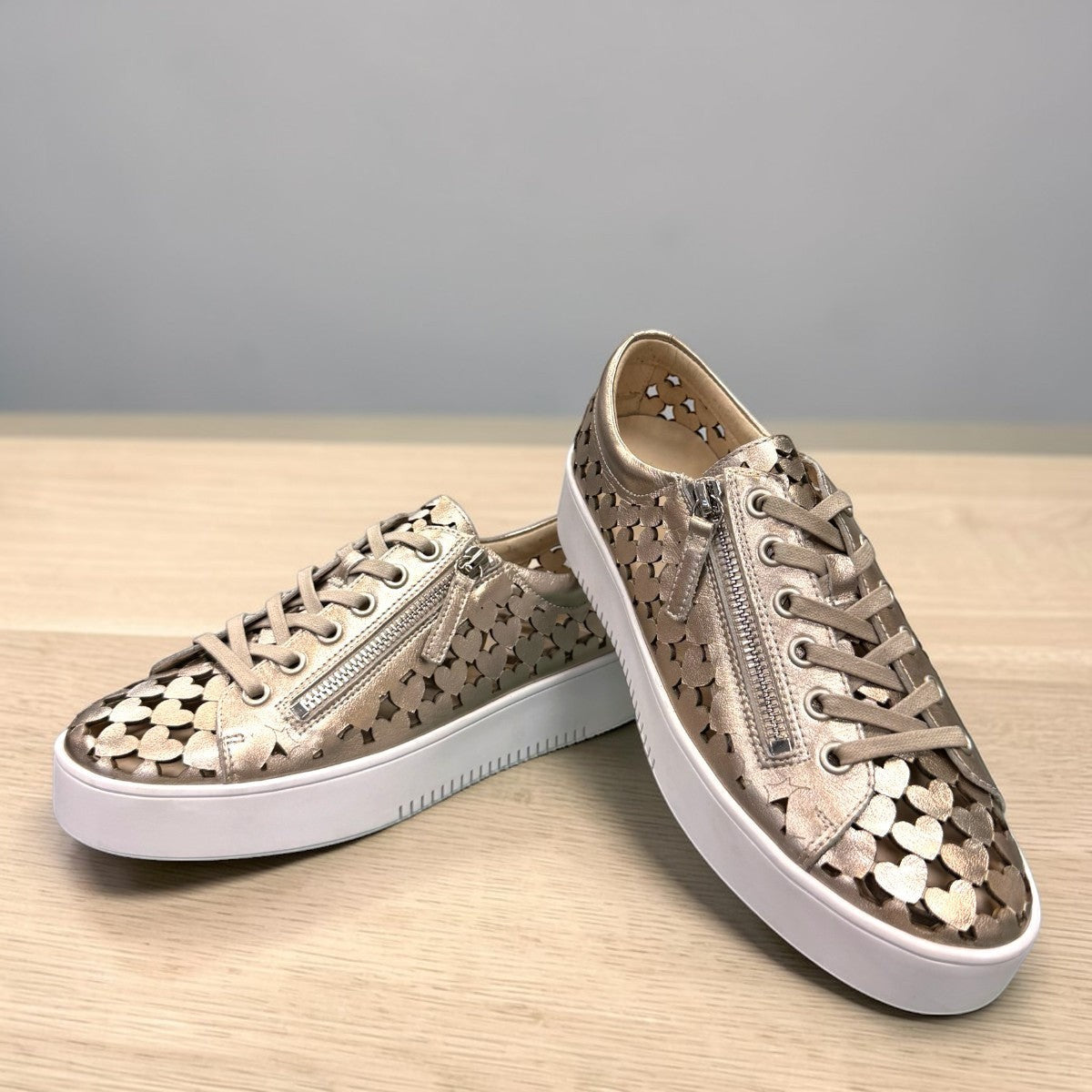 Django & Juliette Leithah metallic platino leather sneakers with heart cutouts and white platform sole. front view.