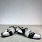 DJANGO & JULIETTE Brynns black and white patent leather slingback Mary Jane flat with buckled straps. front view.