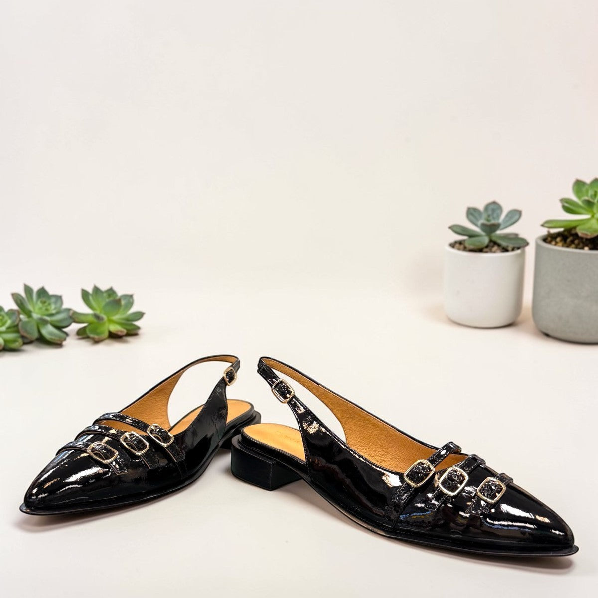 DJANGO & JULIETTE Eshano black patent leather slingback flat with triple buckle detail and low heel. 
front view.