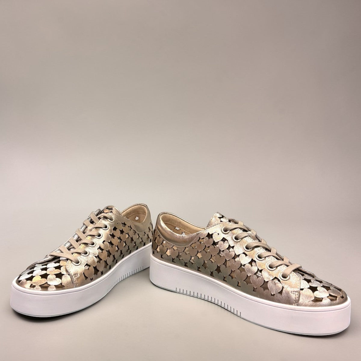 Django & Juliette Leithah metallic platino leather sneakers with heart cutouts and white platform sole. front view.