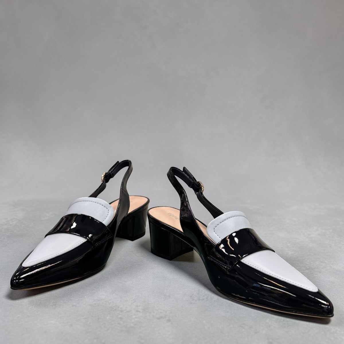 Django & Juliette navy patent leather slingback loafers with a 2-inch block heel and adjustable strap.
front view.