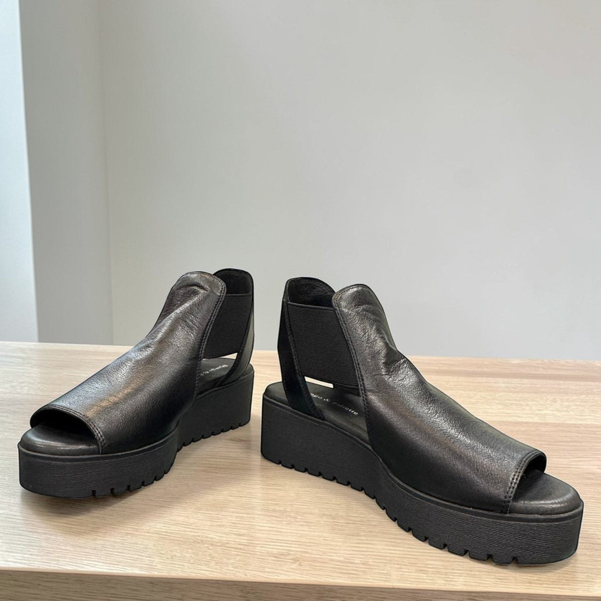 Django & Juliette Ozie black leather wedge sandal with elastic straps and a 2-inch platform sole.  front view.