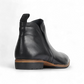 EOS Melborn Gaid black leather ankle boots featuring elastic side gussets and a pull tab on a rubber outsole. Photo of back side view.