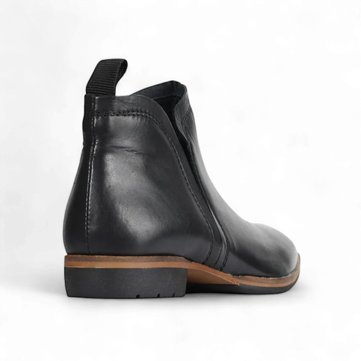 EOS Melborn Gaid black leather ankle boots featuring elastic side gussets and a pull tab on a rubber outsole. Photo of back side view.