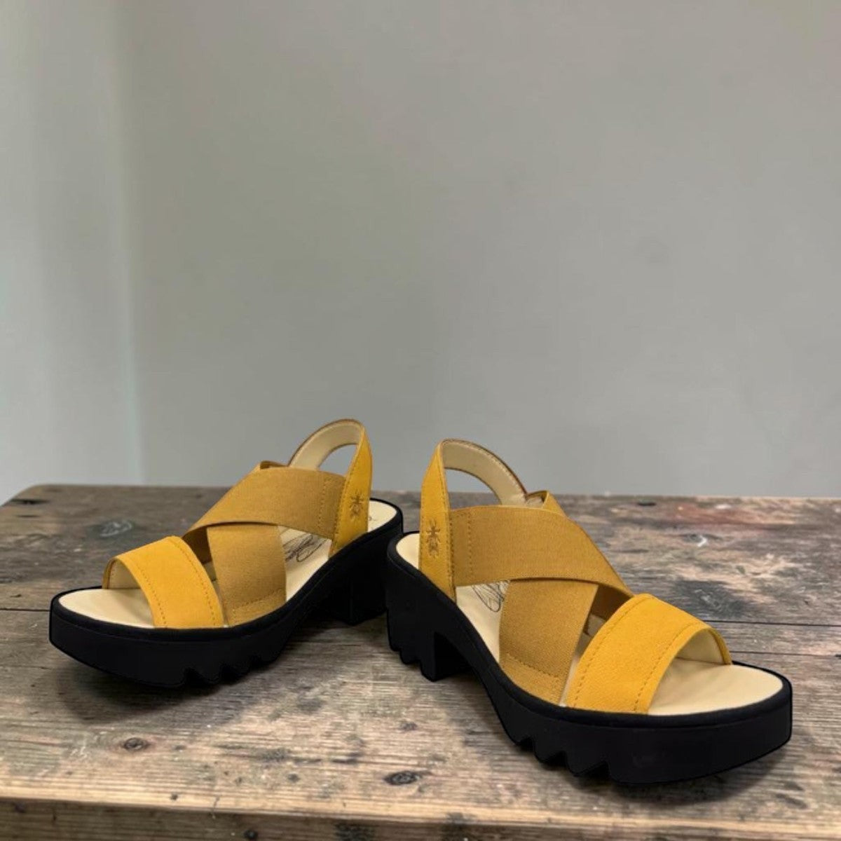 Fly London Taji502fly cupido bumblebee yellow elastic and leather platform sandals with a chunky lugged rubber sole.