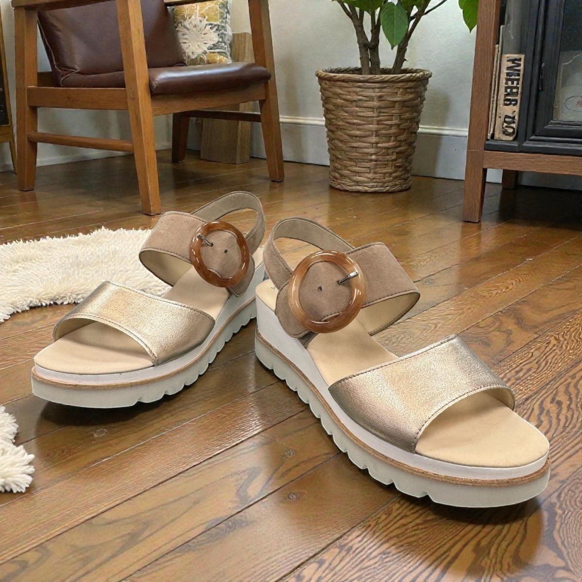 Gabor wedge sandal in metallic gold and suede puder with a decorative buckle and velcro strap. Photo of front side view 1.
