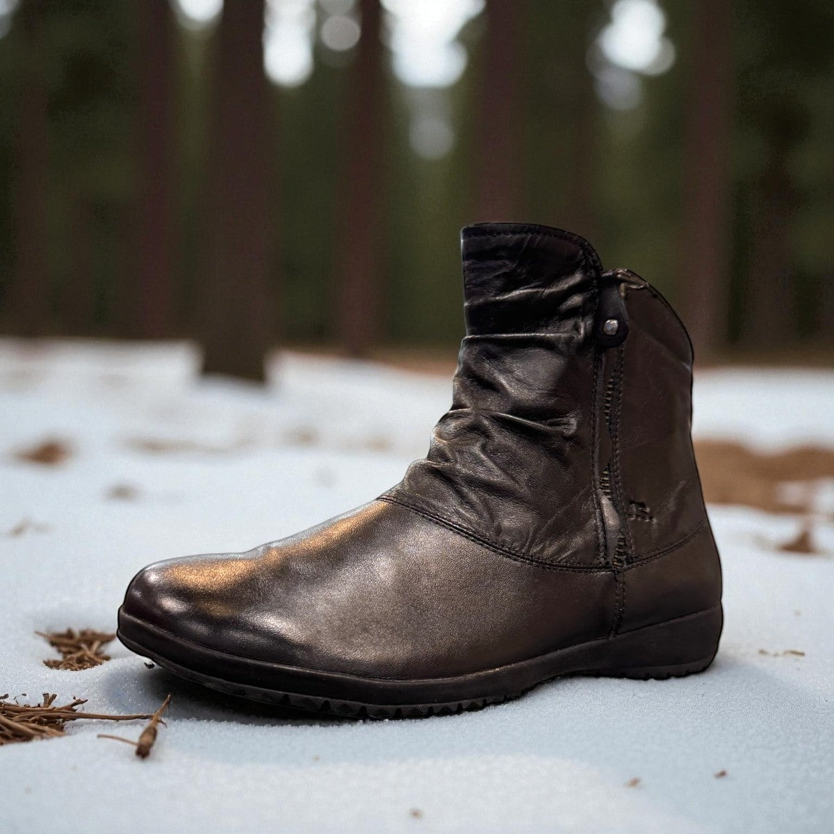 Josef Seibel Naly 24 black leather ruched ankle boot with side zips and low wedge sole.
photo of the front.