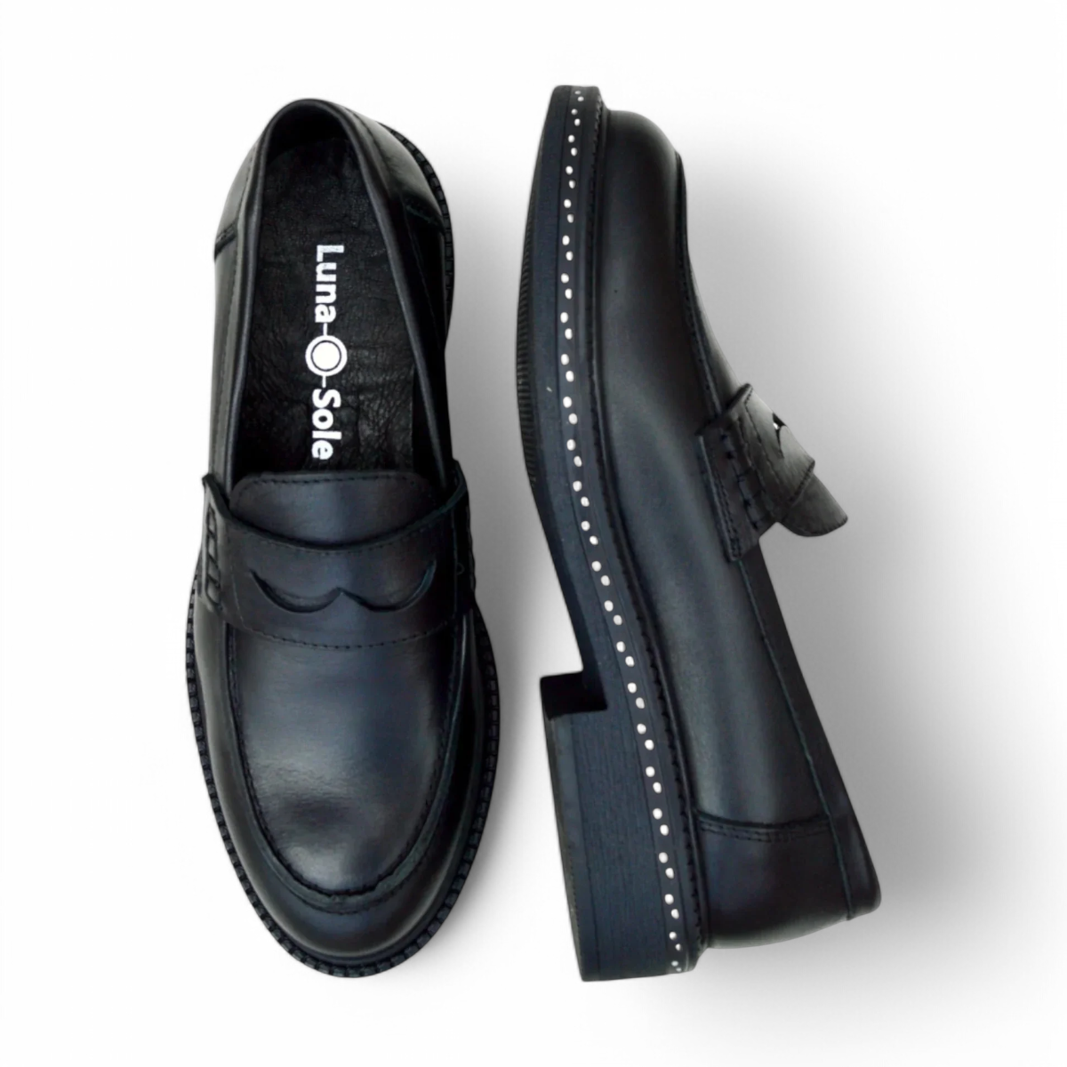 Luna sole pinky black leather loafer with a thick sole featuring white speckled detailing along the welt. Photo of upper view.