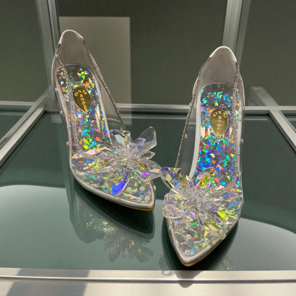 NIKPA BIRILIANT white high heel pump with clear side panels and a large crystal flower embellishment