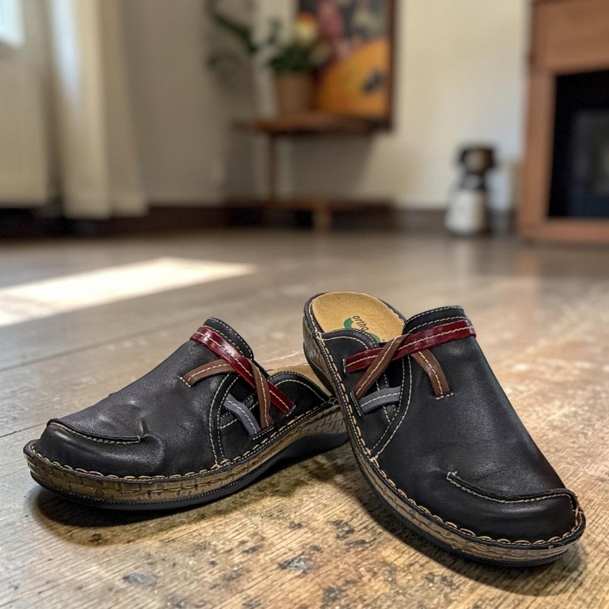 ortho-flex-S6132L black leather comfort clogs with multi-tone strap details, contrast stitching, and a low wedge sole.
photo of the front side