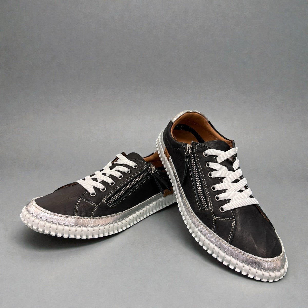 Roamers Audrey black leather sneaker with silver metallic trim, side zipper, and white rubber outsole.
photo of the front side