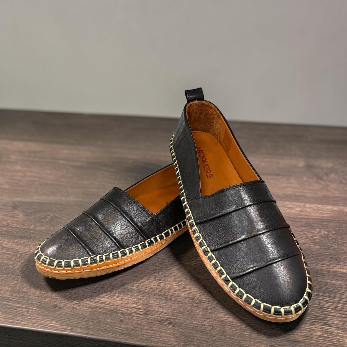 Roamers Avery black leather flat with decorative whipstitch detailing and a durable rubber sole.
photo of the front side