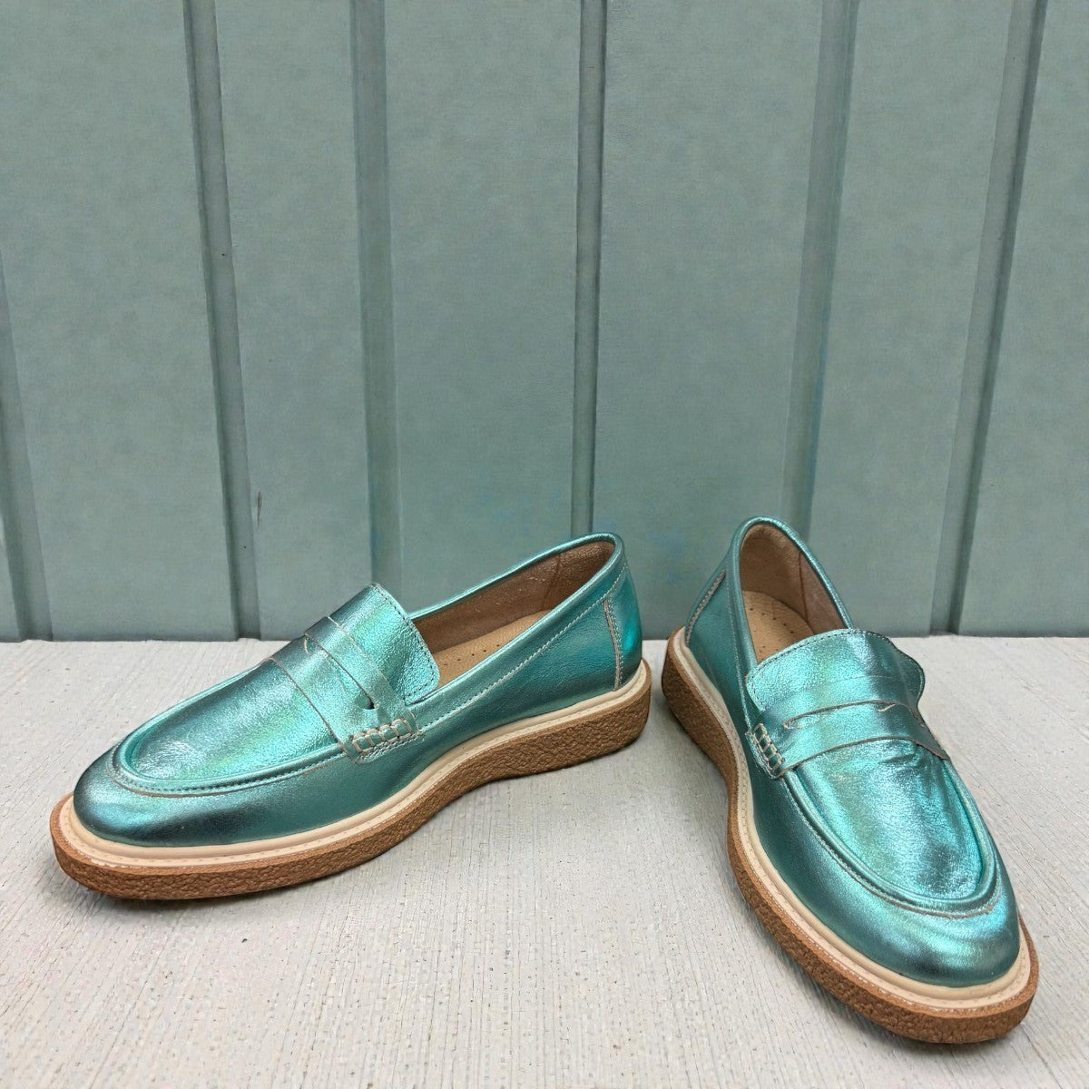 Roamers Nila metallic teal leather loafer with a brown platform sole and moccasin-style stitching.
photo of the front side