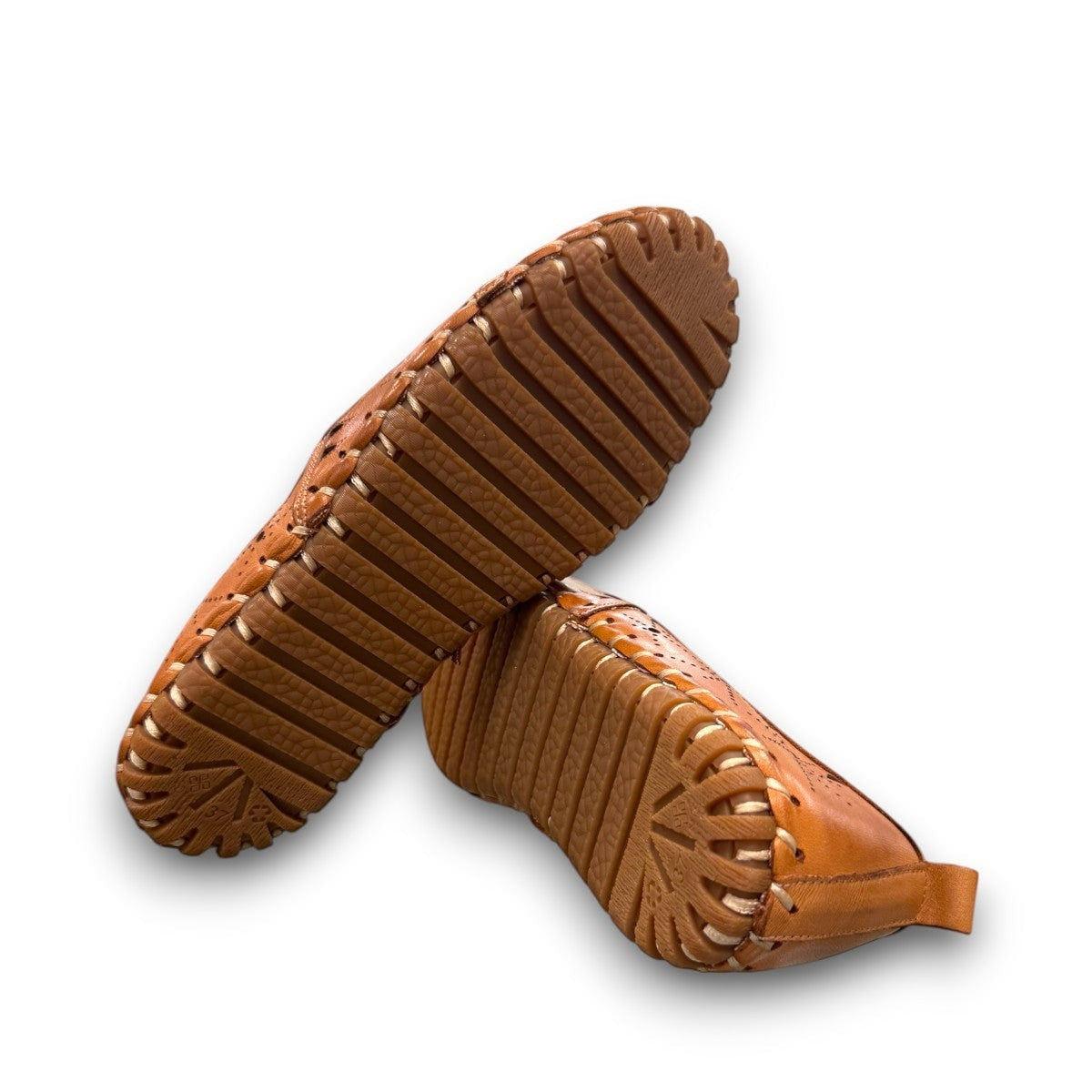 roamers tan leather slip-on loafer with geometric laser cutouts, artisan stitching, and flexible rubber outsole.
photo of the bottom side
