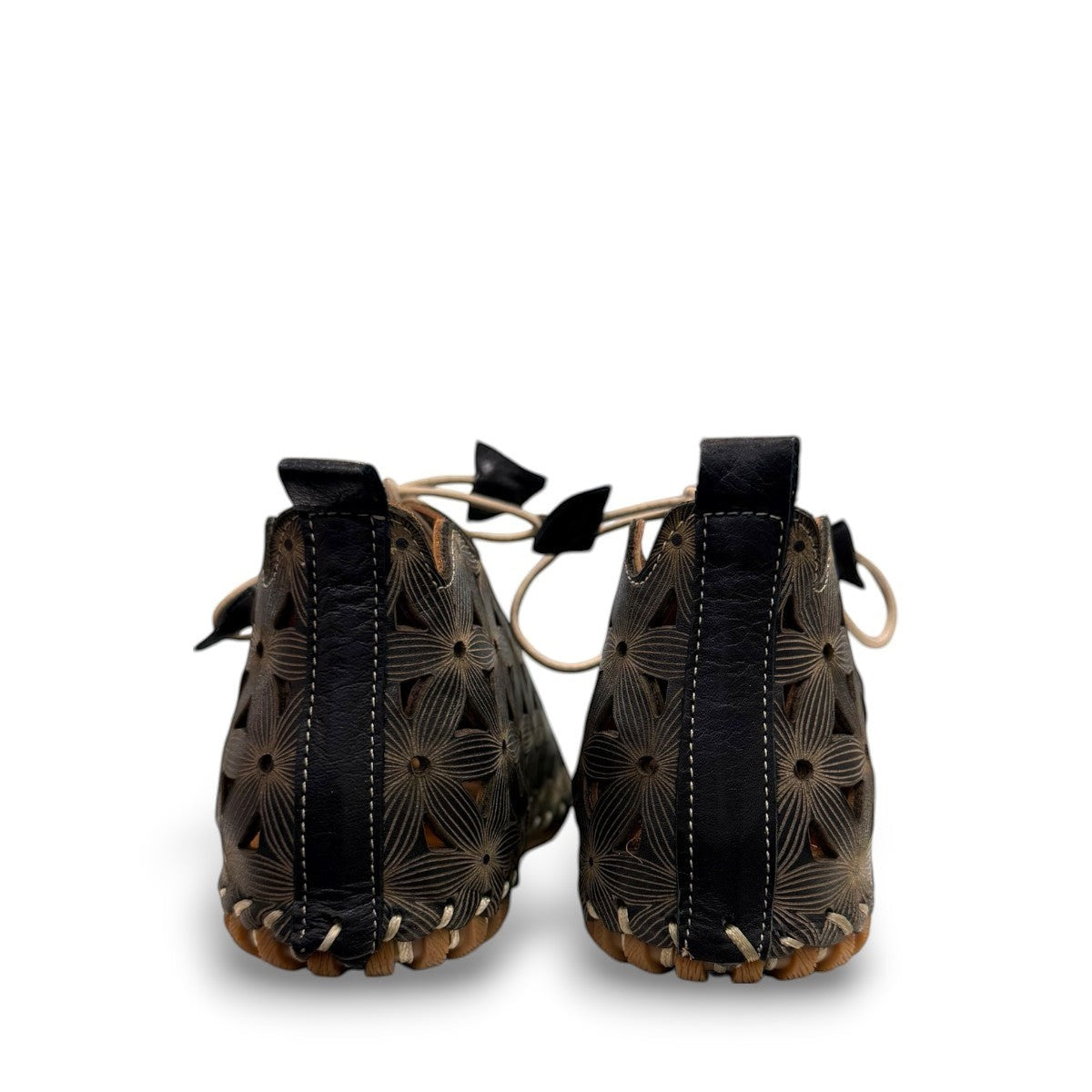 Roamers Venus black leather ankle boots with decorative floral cutouts, elastic lacing, and flat sole.
photo of the back side