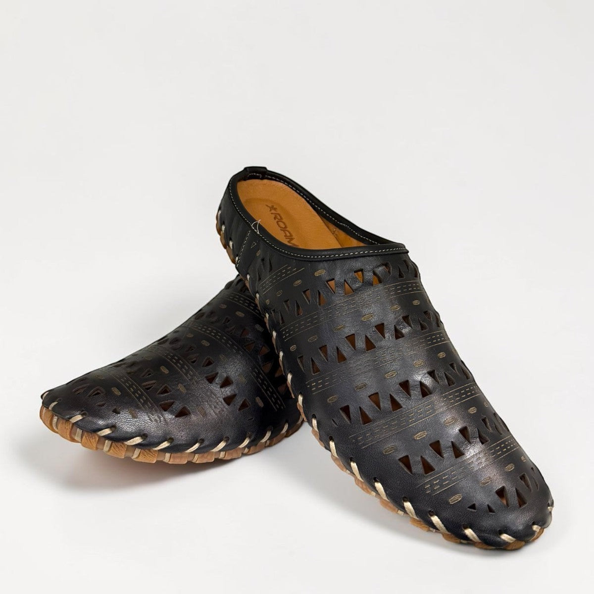 Roamers black leather slip-on mules with perforated cutouts and contrast stitching on a rubber sole.
photo of the front side