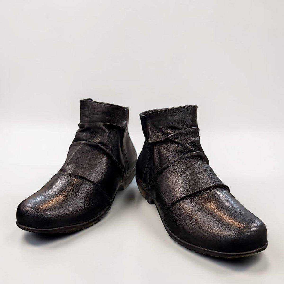 Ros Hommerson Esme black leather ankle bootie with ruched vamp detailing and a low stacked heel.
photo of the front side