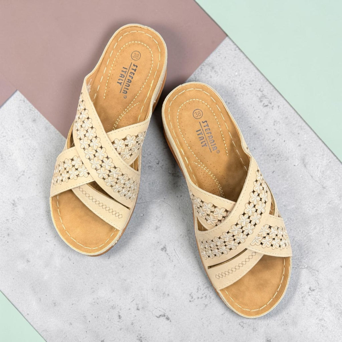 Sina Footwear beige vegan leather slide sandals with floral cut-out straps and a cushioned comfort sole.
photo of the top side
