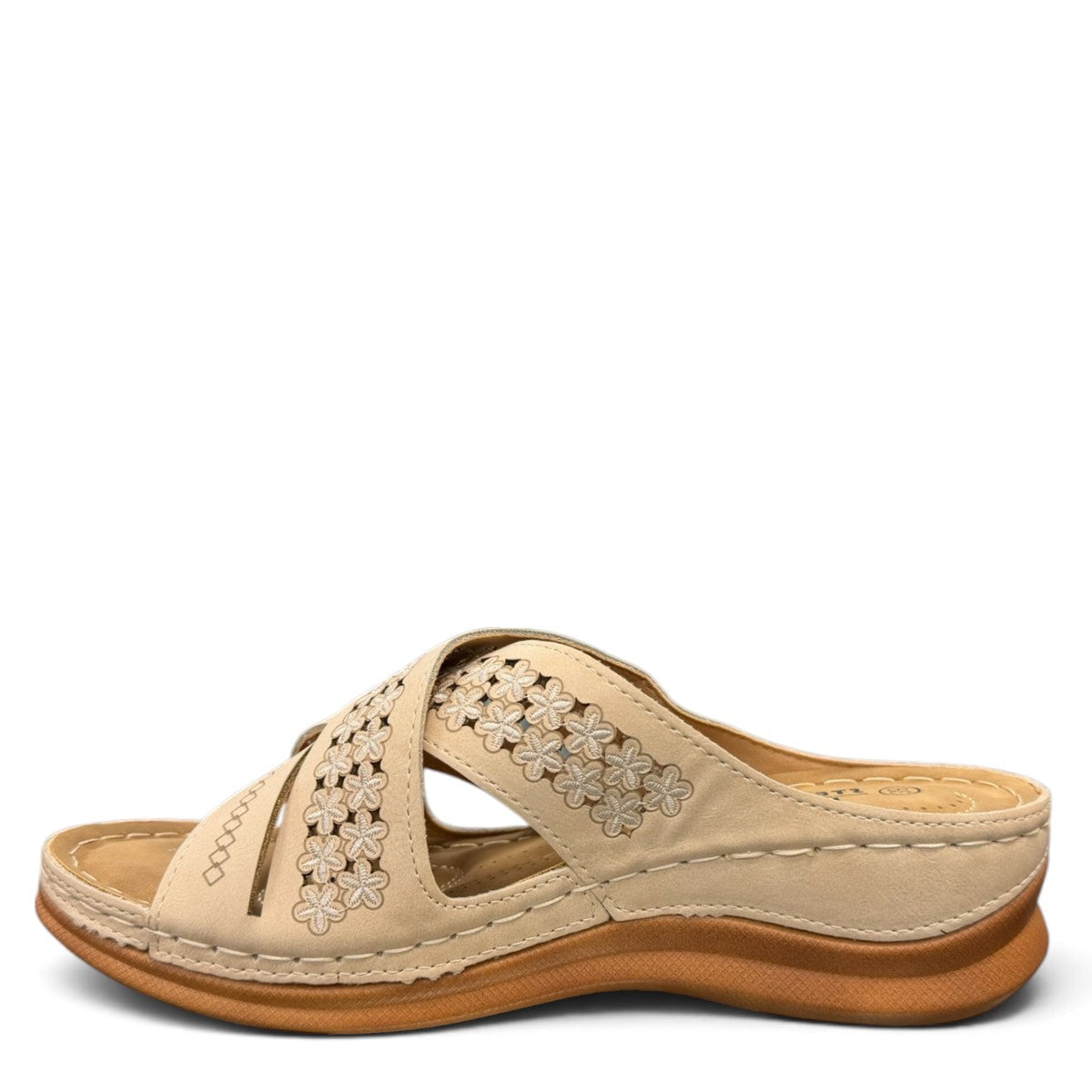 Sina Footwear beige vegan leather slide sandals with floral cut-out straps and a cushioned comfort sole.
photo of the left side