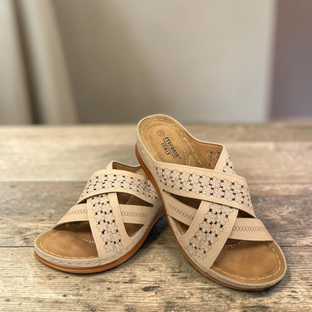 Sina Footwear beige vegan leather slide sandals with floral cut-out straps and a cushioned comfort sole.
photo of the front side