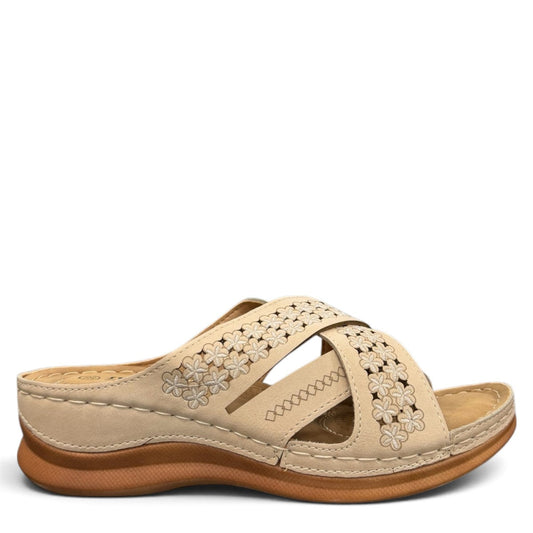 Sina Footwear beige vegan leather slide sandals with floral cut-out straps and a cushioned comfort sole.
photo of the right side