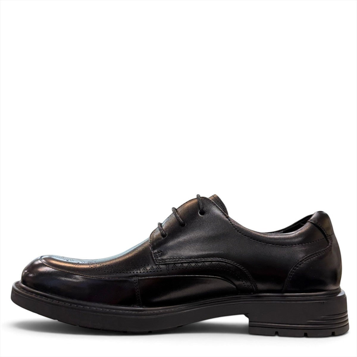 Sina Footwear black leather derby shoe with brogue-inspired perforations and a lightweight chunky rubber sole.
photo of the left side