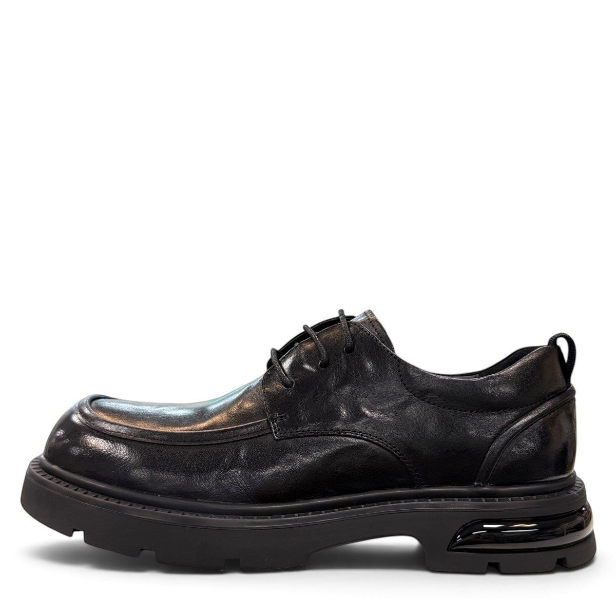 Sina Footwear black leather derby shoe with a chunky lug sole and lace-up closure in a modern silhouette.
photo of the left side