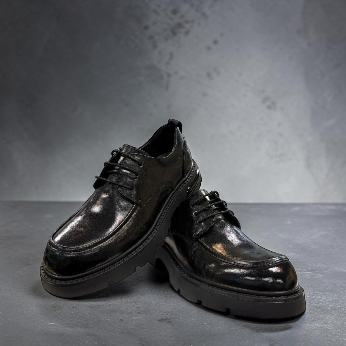 Sina Footwear black leather derby shoe with a chunky lug sole and lace-up closure in a modern silhouette.
photo of the front side