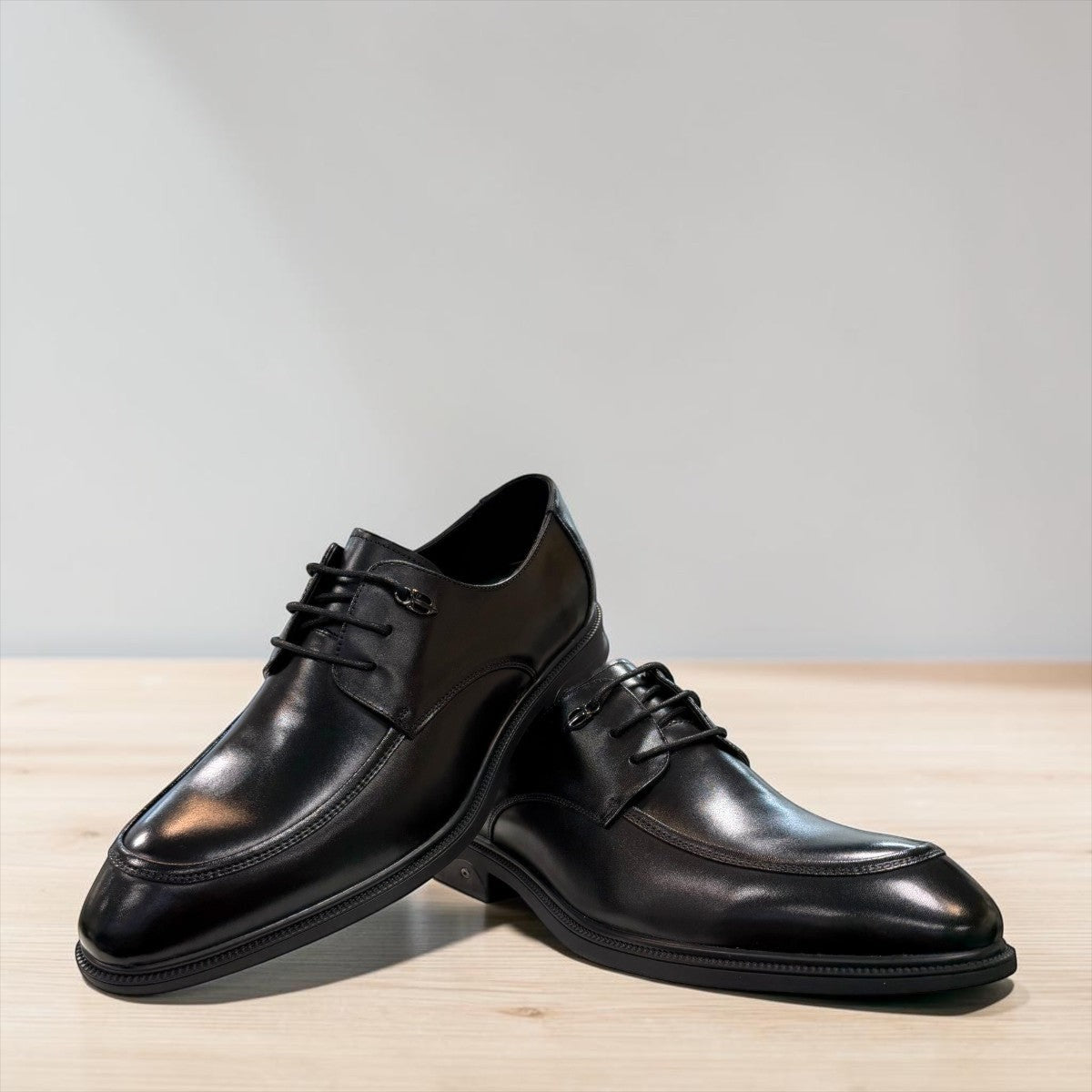 Sina Footwear black leather derby shoes with apron-toe construction, lace-up closure, and durable rubber outsole.
photo of the front side