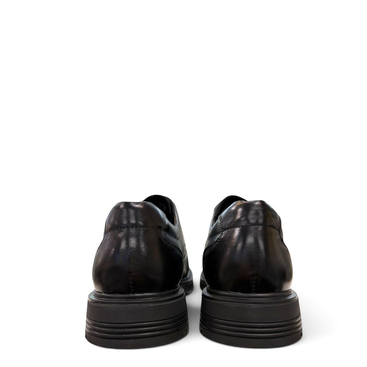 Sina Footwear black leather derby shoe with brogue-inspired perforations and a lightweight chunky rubber sole.
photo of the back side