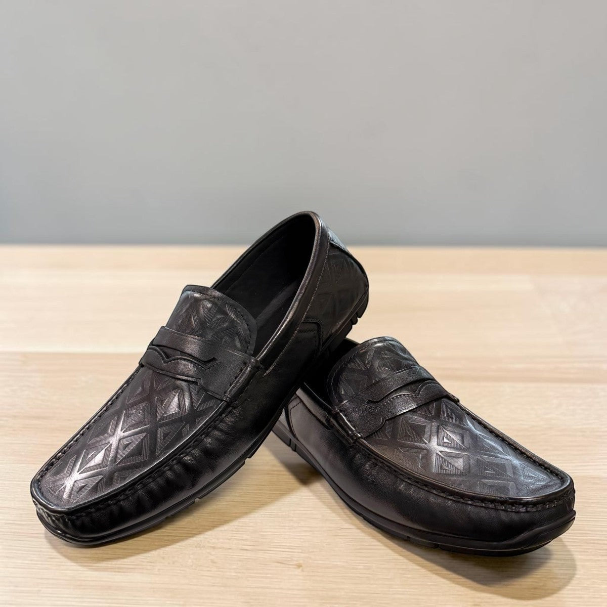 Sina Footwear black genuine leather loafer with embossed geometric pattern and slip-on design.
 photo of the front side