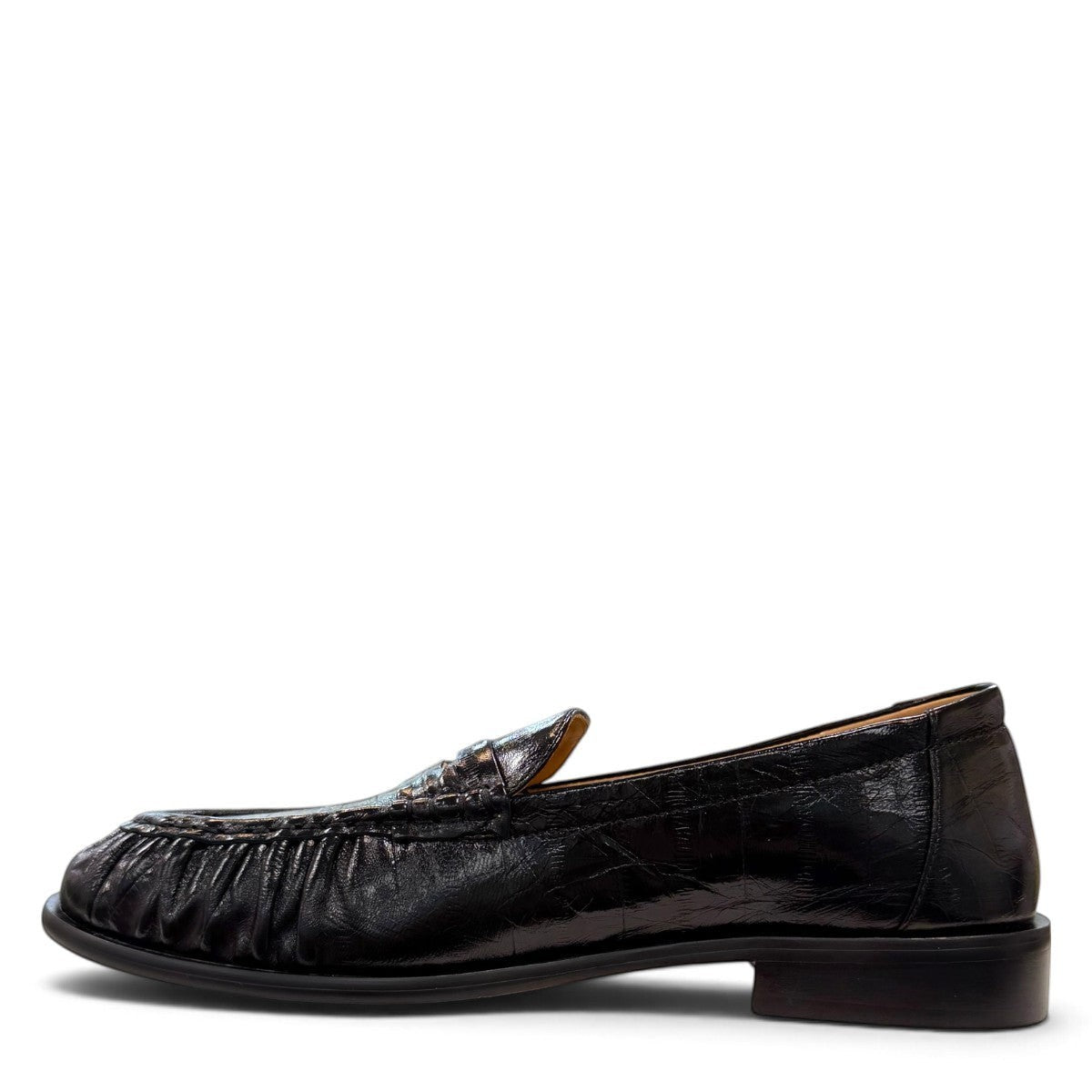 Sina Footwear black genuine leather slip-on loafer with hand-finished gathered detailing and a durable rubber outsole.
photo of the left side