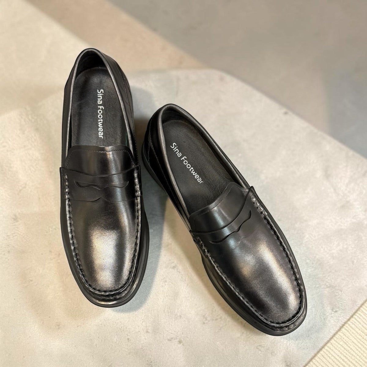 Sina Footwear black genuine leather loafer with a classic slip-on silhouette, cushioned footbed, and rubber outsole.
photo of the top side