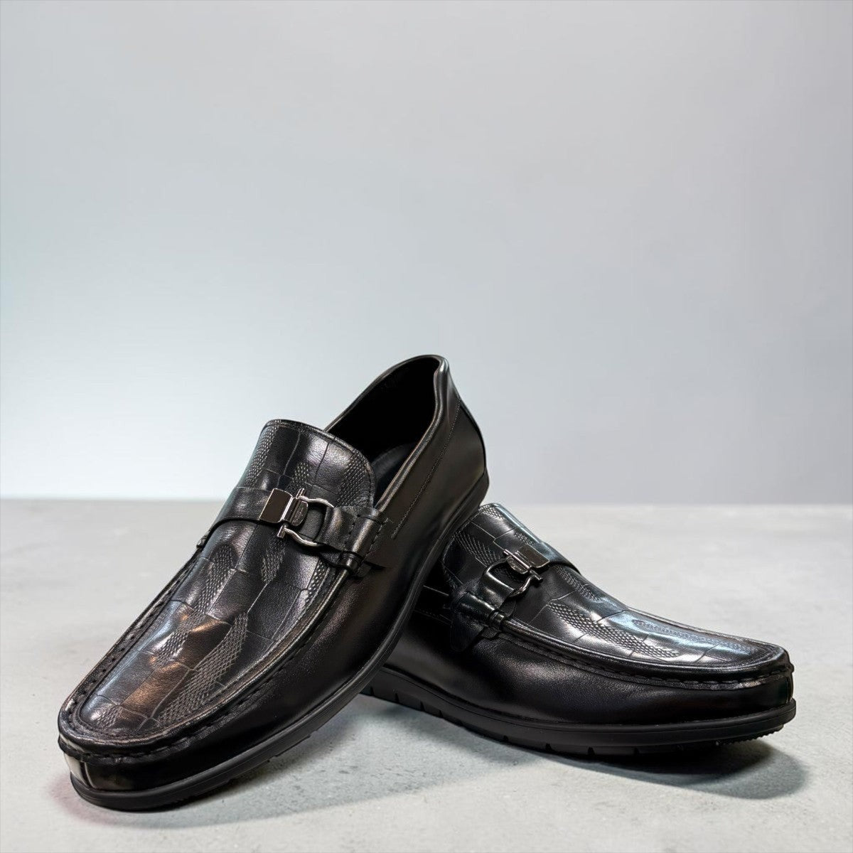 Sina Footwear black genuine leather loafer with a textured vamp strap and durable rubber outsole.
photo of the front side