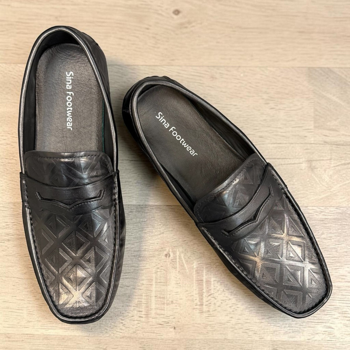 Sina Footwear black genuine leather loafer with embossed geometric pattern and slip-on design.
 photo of the top side