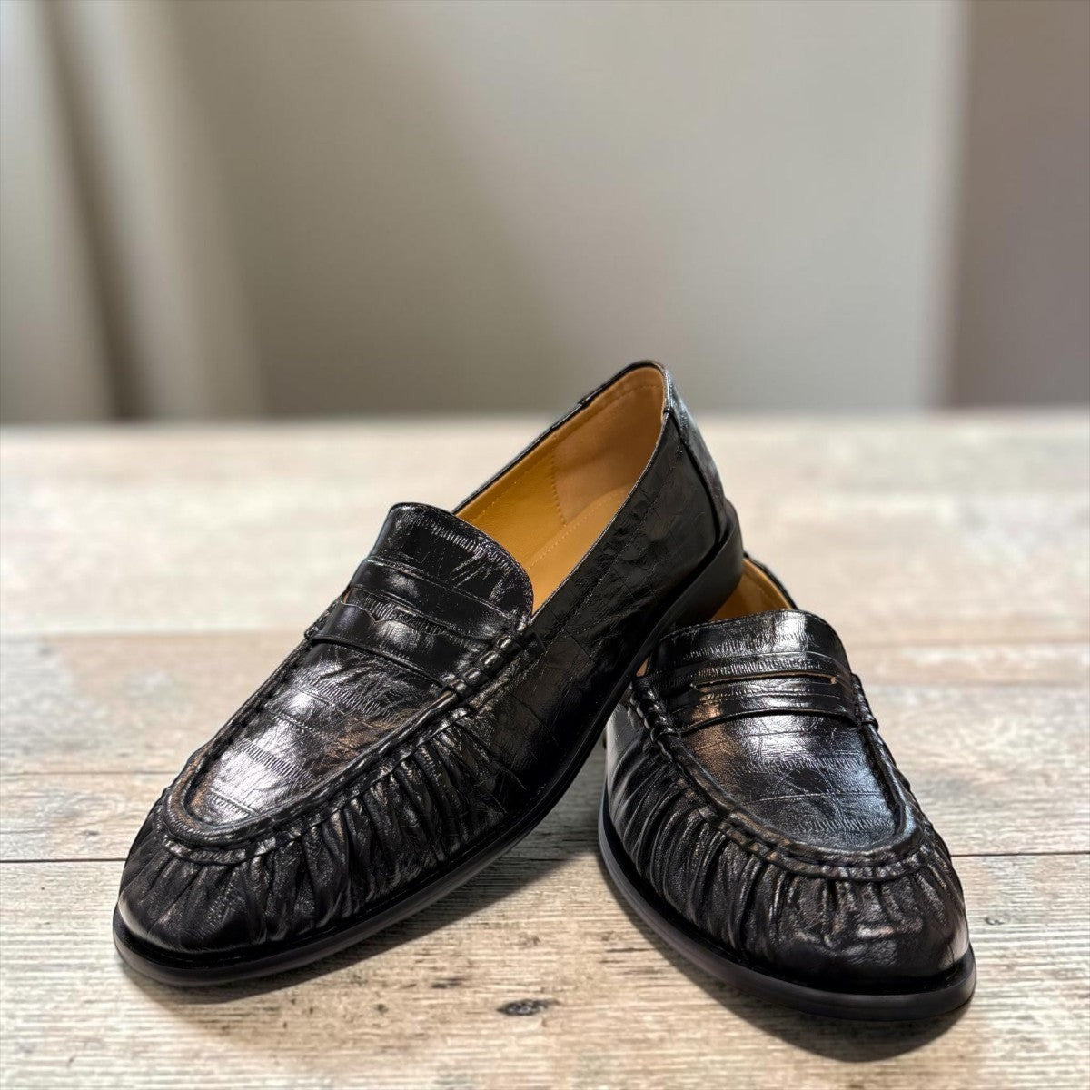 Sina Footwear black genuine leather slip-on loafer with hand-finished gathered detailing and a durable rubber outsole.
photo of the front side
