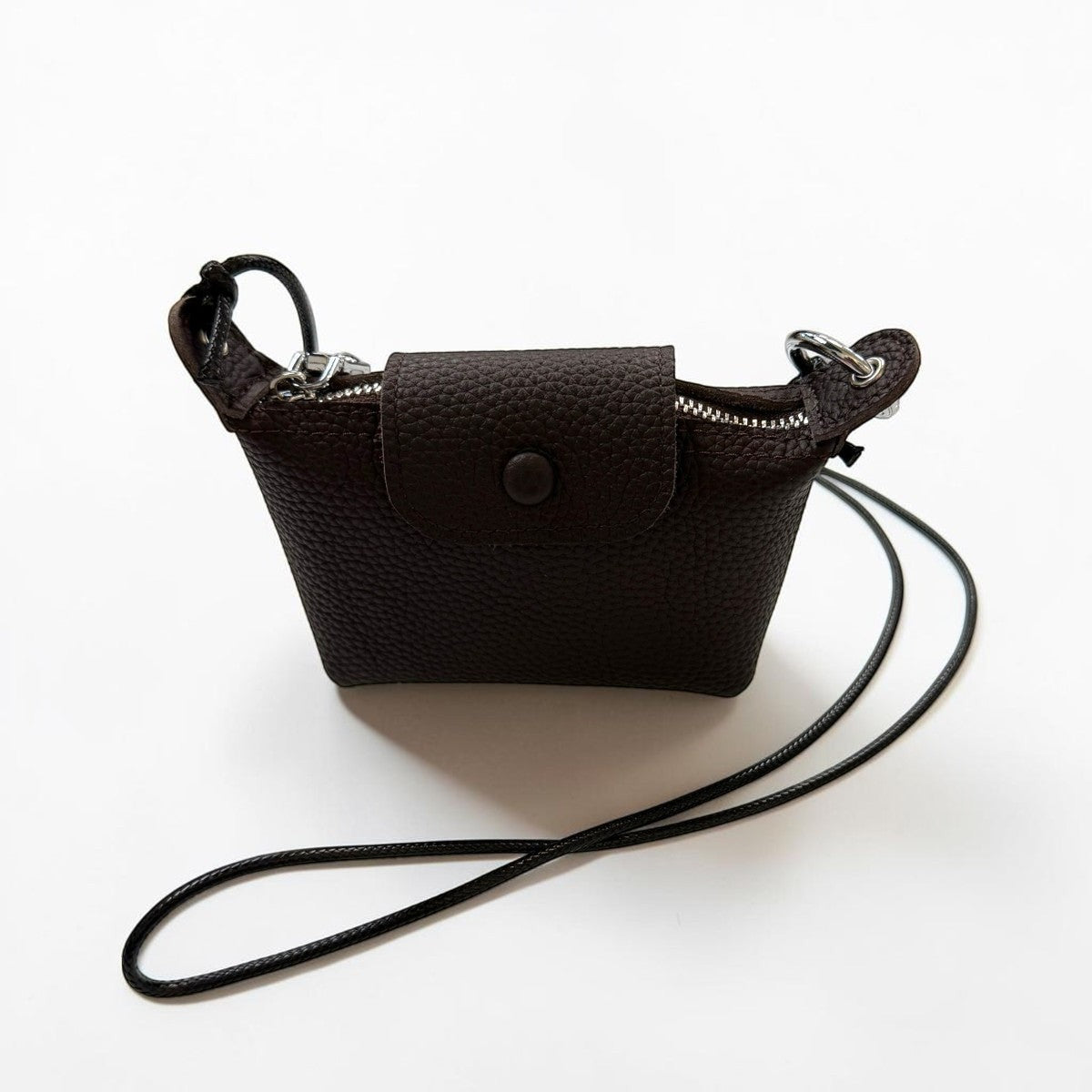 Sina Footwear dark brown pebbled leather mini crossbody wallet with snap closure and zipper.
