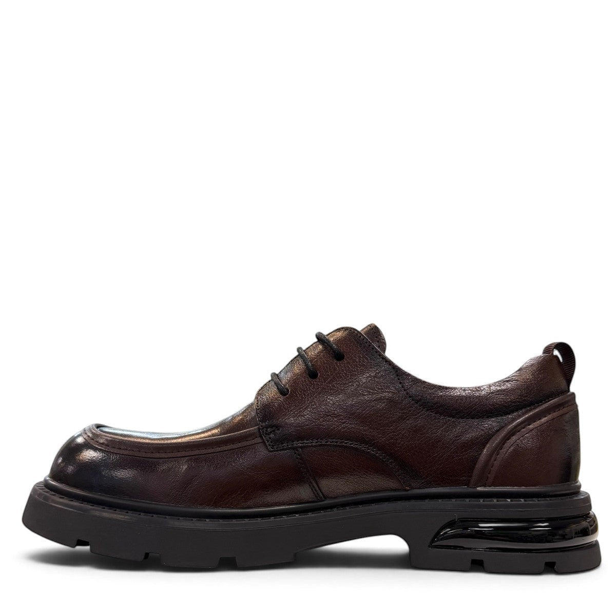 Sina Footwear dark brown leather derby shoe with a chunky black lug sole and lace-up closure.
photo of the left side
