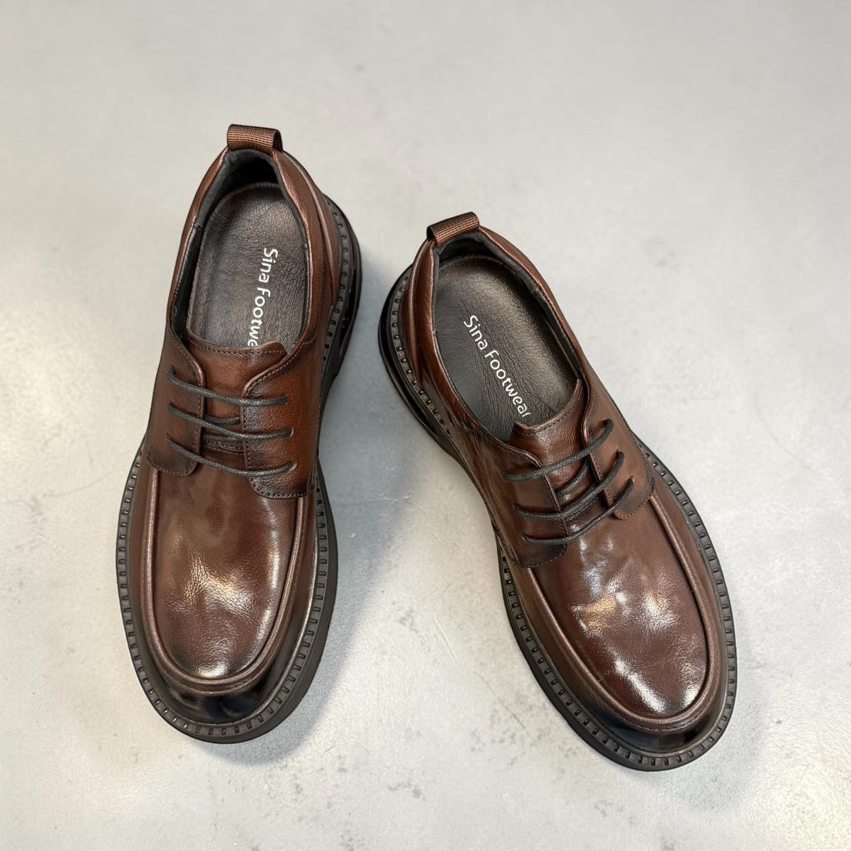 Sina Footwear dark brown leather derby shoe with a chunky black lug sole and lace-up closure.
photo of the top side